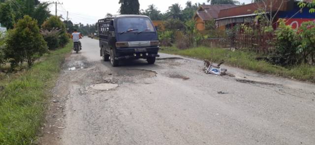 Poto : Jalan lintas Kecamatan Seruway yang berlubang. lokasi tepatnya kurang lebih 50 meter dari Kedai Saring Coffe Kampung Tangsi Lama. Dok : SWARA45.COM/Afrizal]