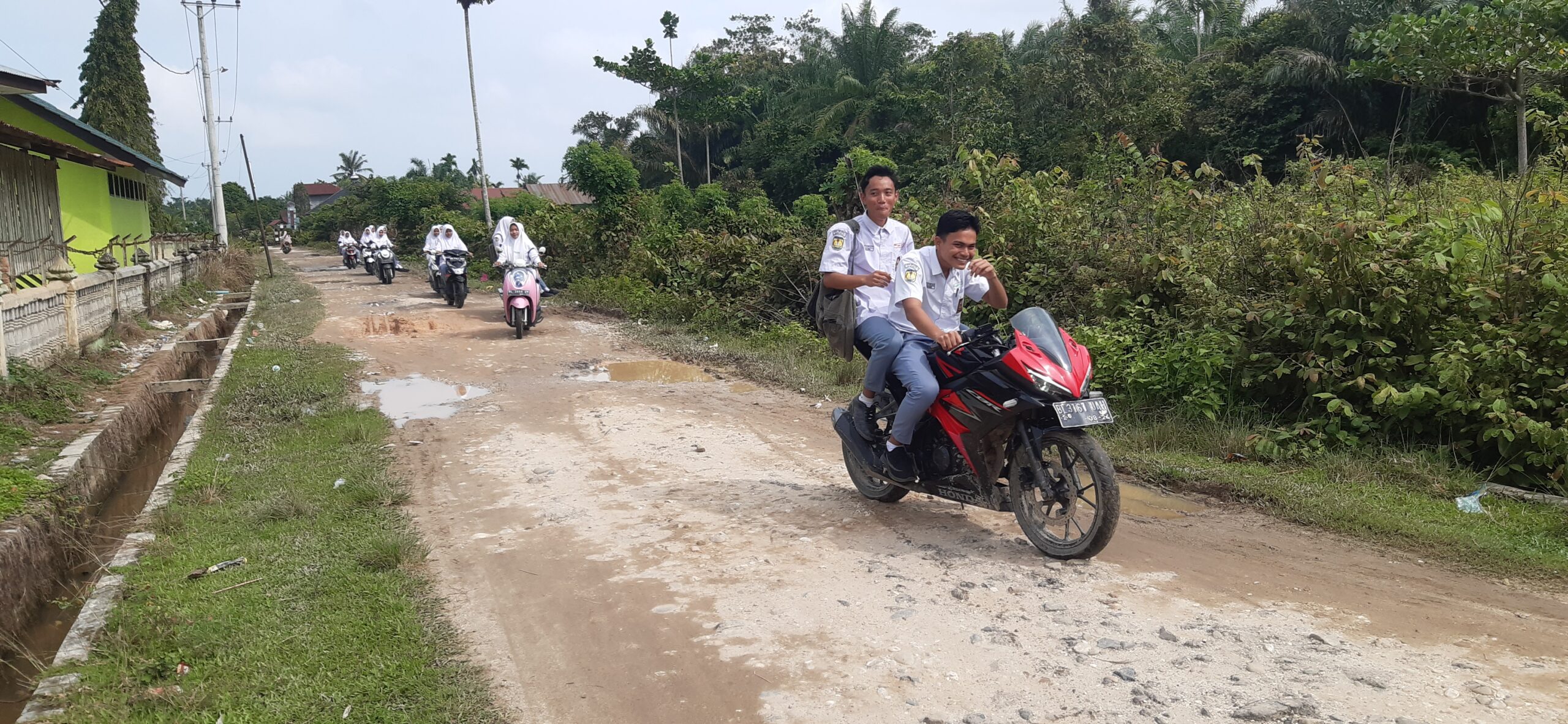 Poto : Depan jalan masuk Dusun Harapan Jaya Desa Tangsi Lama saat Siswa SMA Negeri Seruway keluar dari Dusun itu, Senin (21/11/2022). Dok : SWARA45.COM/Afrizal]