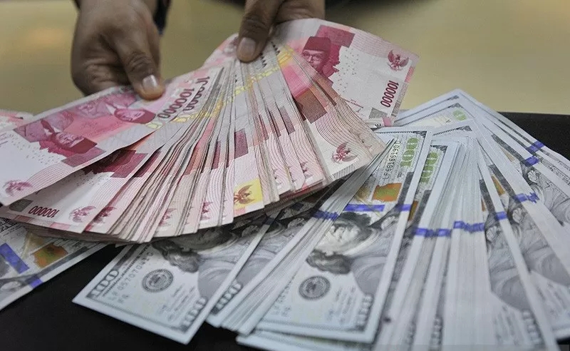 Ilustrasi - Seorang teller sebuah bank merapikan lembaran mata uang rupiah dan dolar Amerika di Jakarta. Dok : ANTARA FOTO/Puspa Perwitasari/am)