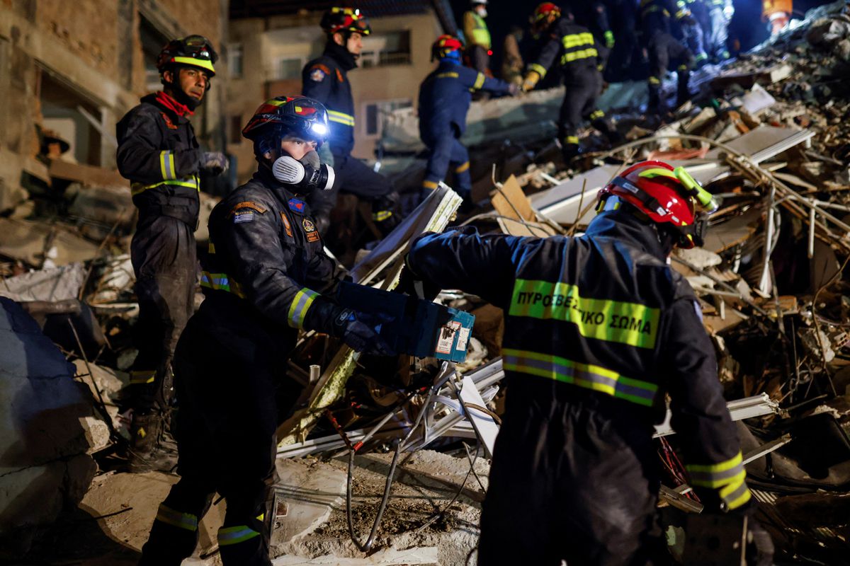 Anggota tim penyelamat Yunani bekerja di lokasi bangunan yang runtuh, saat pencarian korban selamat berlanjut, setelah gempa mematikan, di Hatay, Turki 11 Februari 2023. REUTERS/Kemal Aslan.