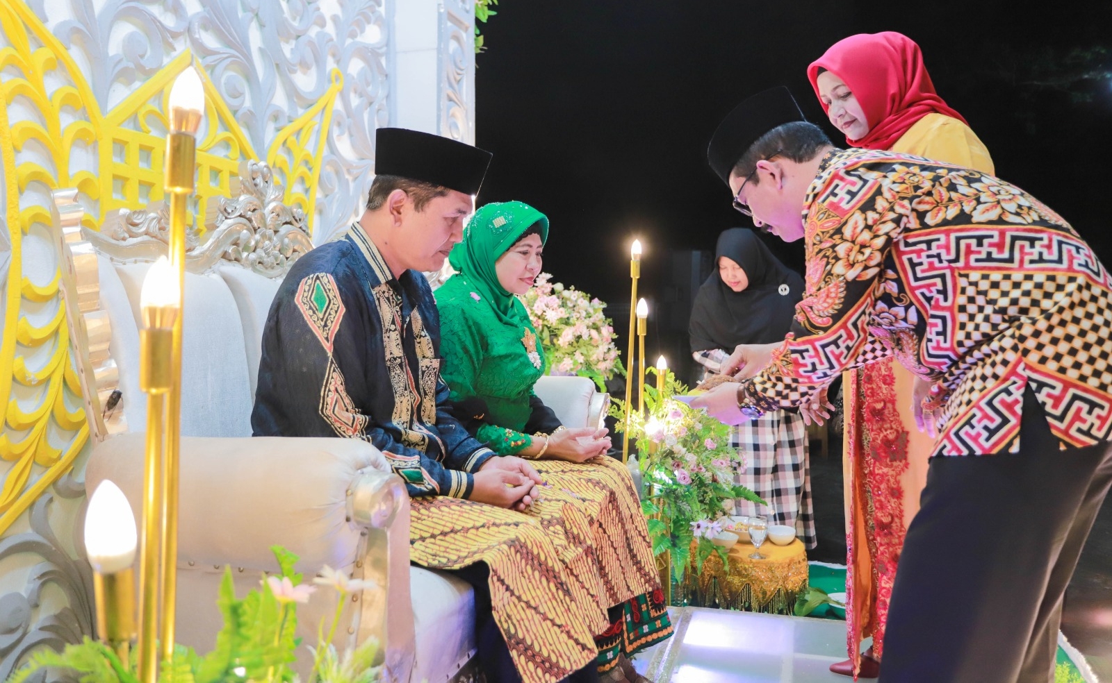 Pj. Bupati Aceh Tamiang, Dr. Drs. Meurah Budiman, SH, MH, beserta Istri sedang melakukan prosesi tepung tawar kepada Kepala Kejaksaan Negeri Aceh Tamiang, joko Wibisono, SH, MH beserta istri. Dok. Prokopim 2023)