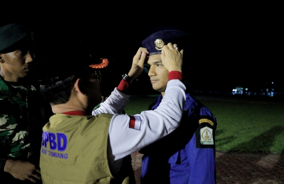Pj. Bupati Aceh Tamiang Dr. Drs. Meurah Budiman, SH, MH, memasangkan baret kepada perwakilan peserta saat penutupan Diklat Tingkat I bagi Petugas Damkar, Kamis (16/2/2023) malam.