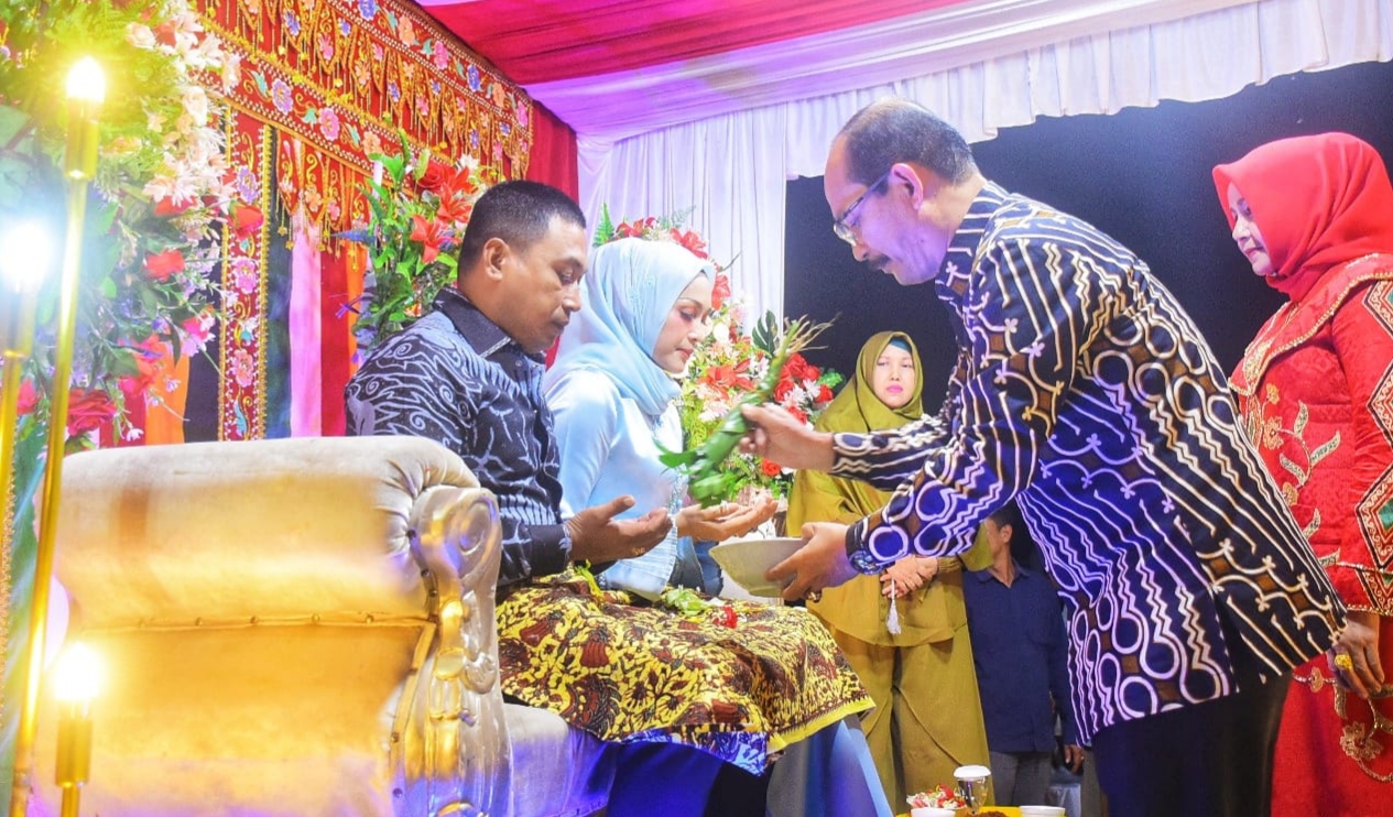 Pj. Bupati Aceh Tamiang, Drs. Meurah Budiman, SH, MH, menepung tawari AKBP Muhammad Yanis, S.I.K, MH dan isteri sebagai pejabat Kapolres Aceh Tamiang yang baru saat pisah sambut Kapolres di Pendopo Bupati Aceh Tamiang, Jumat (13/1/2023).