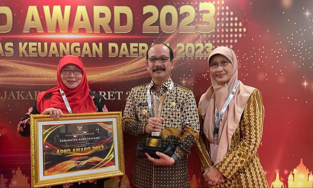 Pj. Bupati Aceh Tamiang, Dr. Drs. Meurah Budiman, SH, MH didampingi Asisten Ekonomi dan Pembangunan dr. Catur Hariyati, MARS (kanan) dan Kepala BPKD, Yusriati, SE, M.Si, Ak (kiri) saat menerima penghargaan. [Dok. Prokopim 2023]