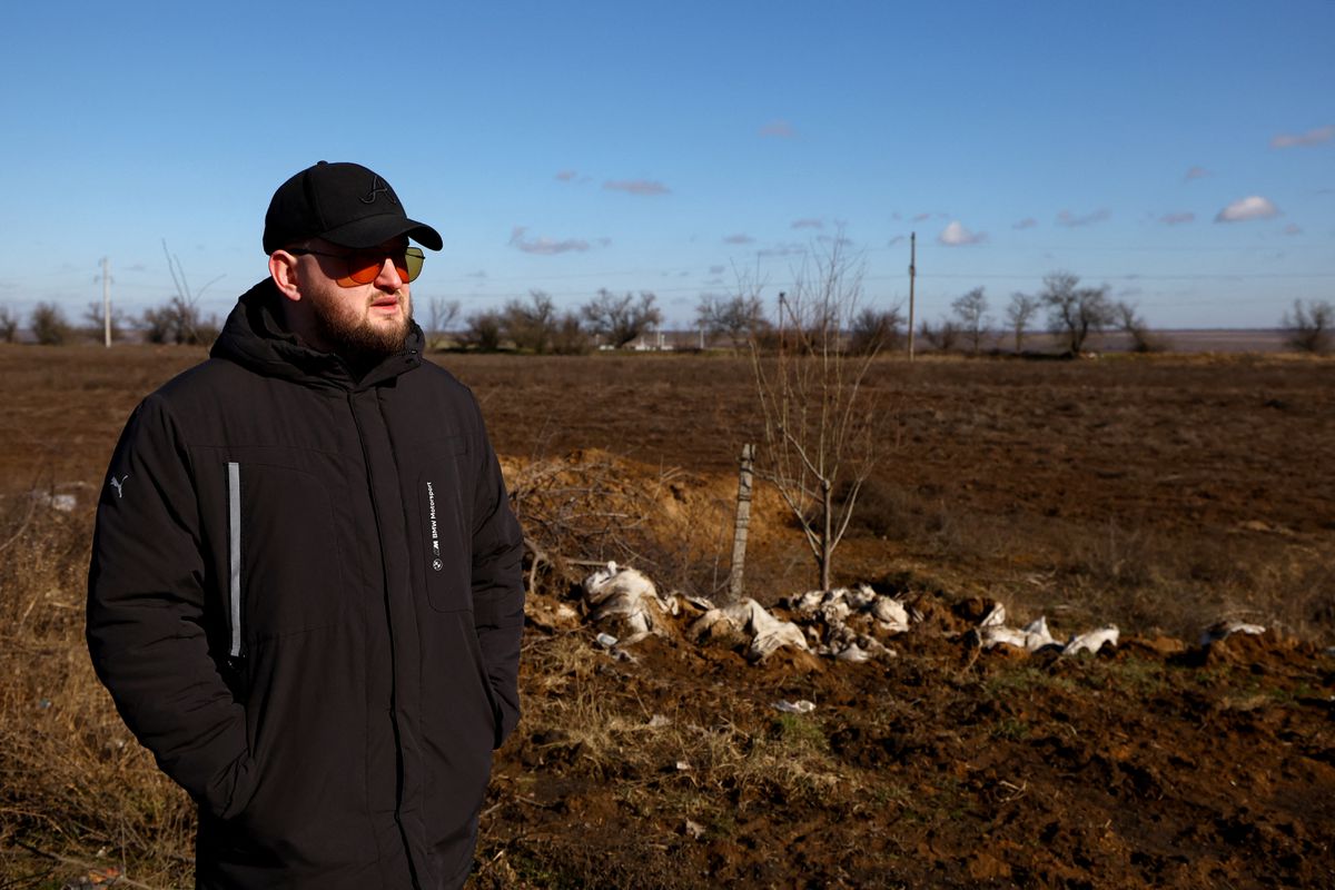 Petani biji-bijian Andrii Povod berdiri di samping ladangnya yang telah rusak akibat penembakan dan parit, di tengah invasi Rusia ke Ukraina, di Bilozerka, wilayah Kherson, Ukraina, 20 Februari 2023. Dok : REUTERS/Lisi)