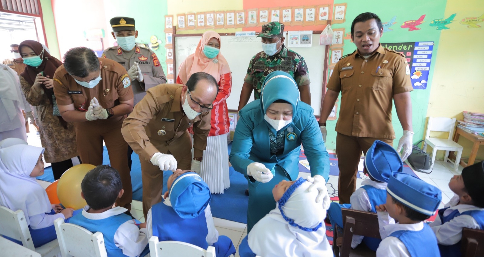 Pj. Bupati Aceh Tamiang, Drs. Meurah Budiman, SH, MH, bersama Ketua TP-PKK Kabupaten, Zuraidah Meurah, Kepala Dinas Kesehatan, dr. Mustakim, M.Kes, Sp.DLP, Ketua DWP, Murniati Asra, Camat dan Forkopimcam Rantau memberikan imunisasi berbentuk tetes manis polio kepada siswa TKN Pembina Rantau.