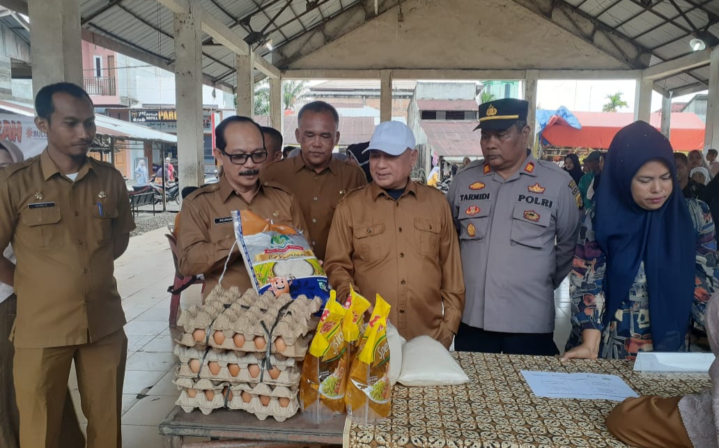 Pj. Bupati Aceh Tamiang, Dr. Drs. Meurah Budiman, SH, MH, mengamati bahan sembako yang dijual dalam operasi pasar yang digelar Dinas Pangan, Kelautan & Perikanan bekerjasama Dinas Pangan Aceh dan Perum Bulog Kantor wilayah Aceh, di Pekan Sei Iyu, Bendahara.