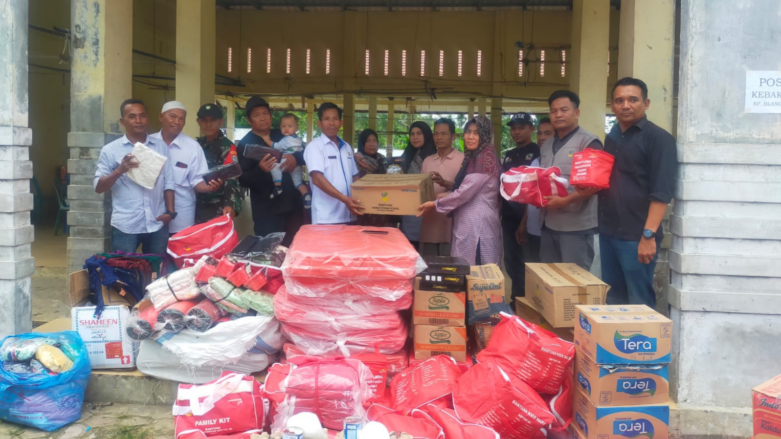 Proses penyerahan bantuan tnggap darurat oleh Dinsos Aceh Tamiang kepada Datok Penghulu Kampung Blang Kandis, Bandar Pusaka.