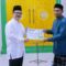 Pj. Bupati Aceh Tamiang, Dr. Drs. Meurah Budiman, SH, MH, menyerahkan bantuan kepada BKM Nurul Mukhlisin, Kampung Upah, Kecamatan Bendahara. Dok: Prokopim/ SWARA45.COM]