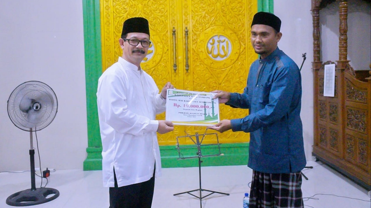 Pj. Bupati Aceh Tamiang, Dr. Drs. Meurah Budiman, SH, MH, menyerahkan bantuan kepada BKM Nurul Mukhlisin, Kampung Upah, Kecamatan Bendahara. Dok: Prokopim/ SWARA45.COM]