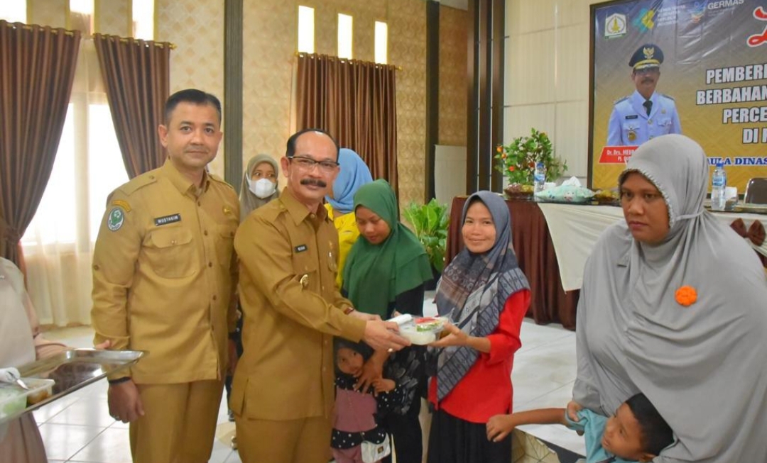 Poto : Pj. Bupati Aceh Tamiang, Dr. Drs. Meurah Budiman, SH, MH, didampingi Kadis Kesehatan saat memberikan secara simbolis makanan tambahan kepada ibu hamil, di aula Dinas Kesehatan setempat, Senin (28/8/2023).