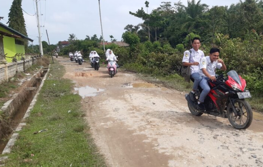 Poto : Depan jalan masuk Dusun Harapan Jaya Desa Tangsi Lama saat Siswa SMA Negeri 1 Seruway keluar dari Dusun tersebut, Senin (21/11/2022). Dok : SWARA45.COM/Afrizal]