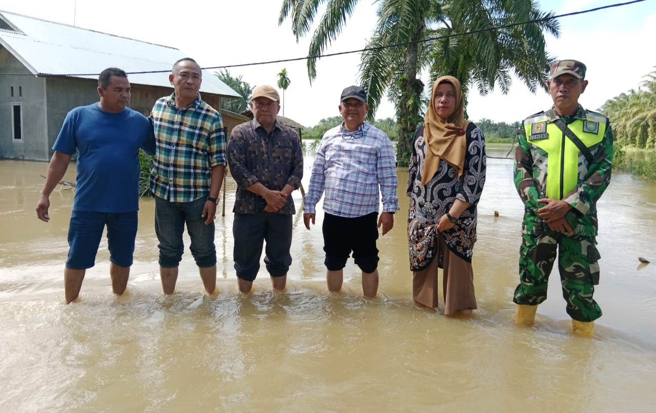 Usai membagikan 300 paket bantuan sembako. Pj Bupati Aceh Tamiang Drs. Asra, berpoto bersama prokopim dilokasi rumah warga yang masih terendam banjir, di Kampung Gelung Kecamatan Seruway. Minggu (31/12/2023). Dok: Humas/ SWARA45.COM/Afrizal)